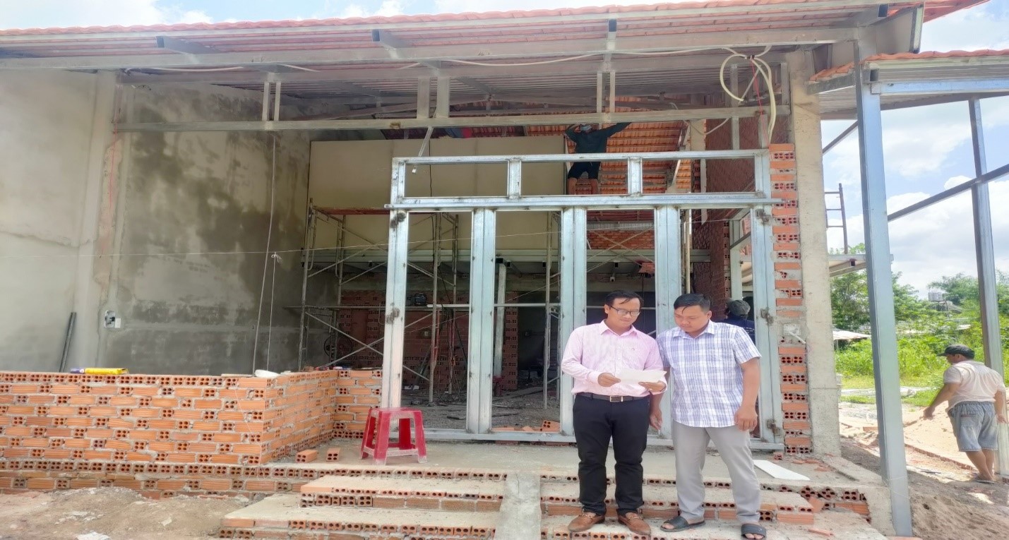 ( Cán bộ NHCSXH huyện kiểm tra tiến độ xây nhà của một hộ vay trên địa bàn)
